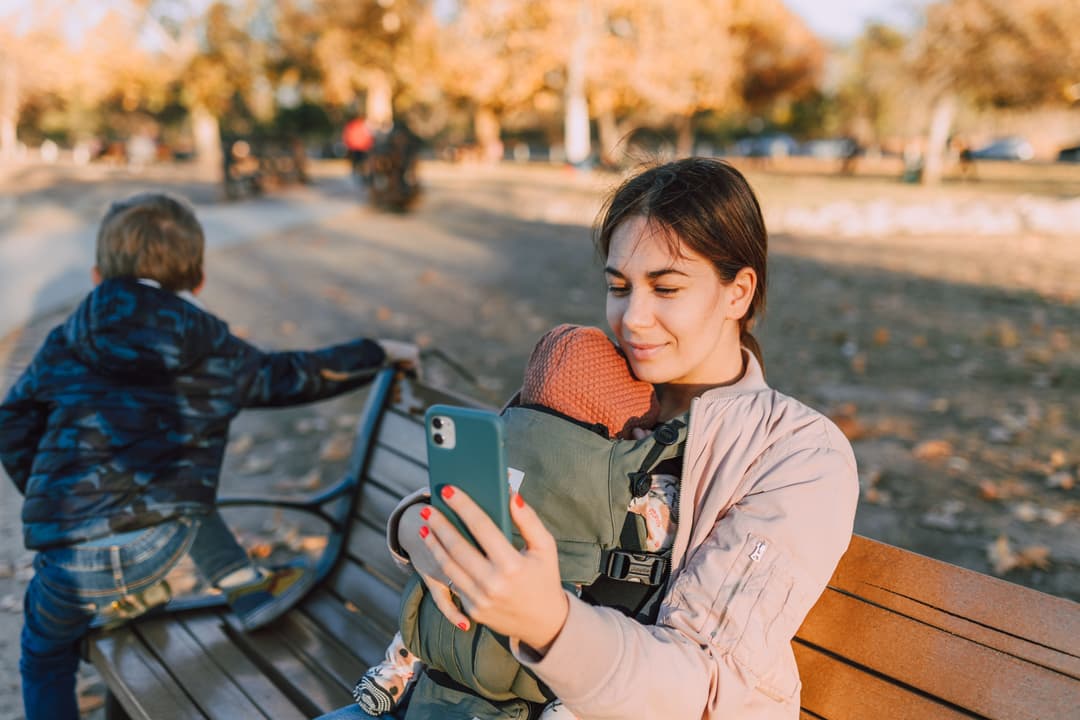 A parent with two children in a park